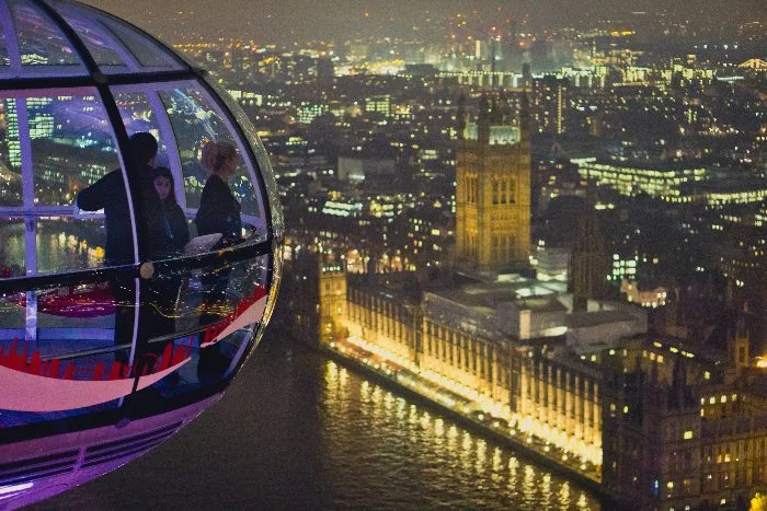 a car of the London Eye and Parliament at night
