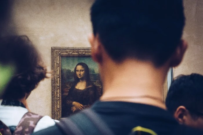 A man looks at the Mona Lisa painting at the Louvre in Paris