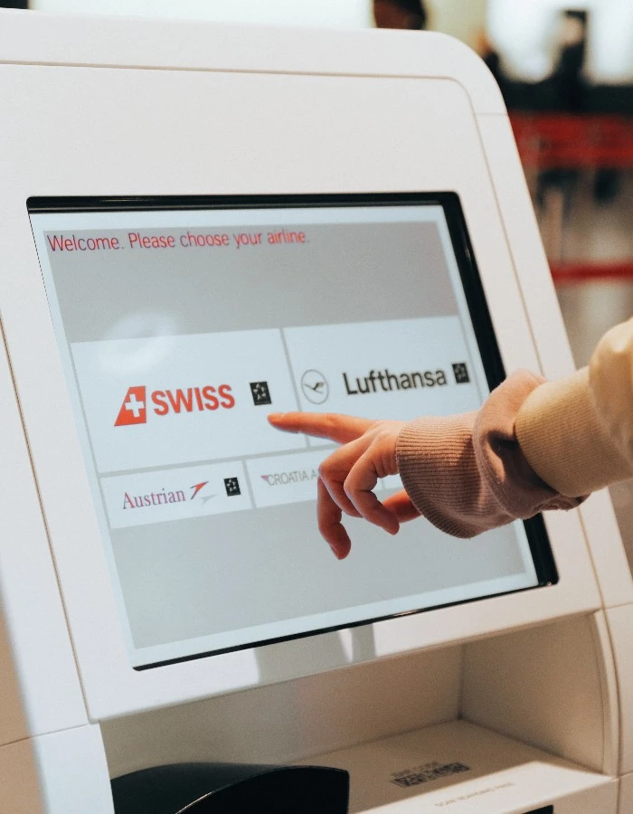 A person checking in for a Swiss flight at an airport kiosk