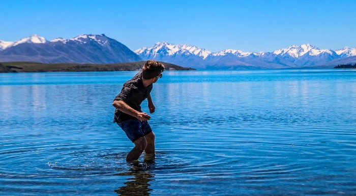 A man skipping rocks in a lake