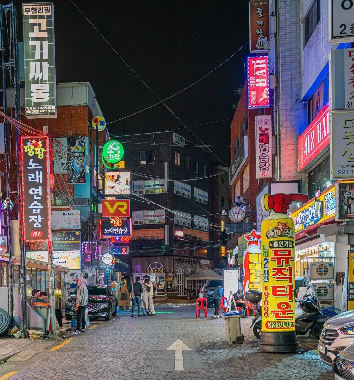 A busy street at night with signs in Korean