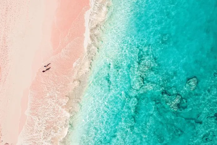 A pink sand beach and blue sea waters