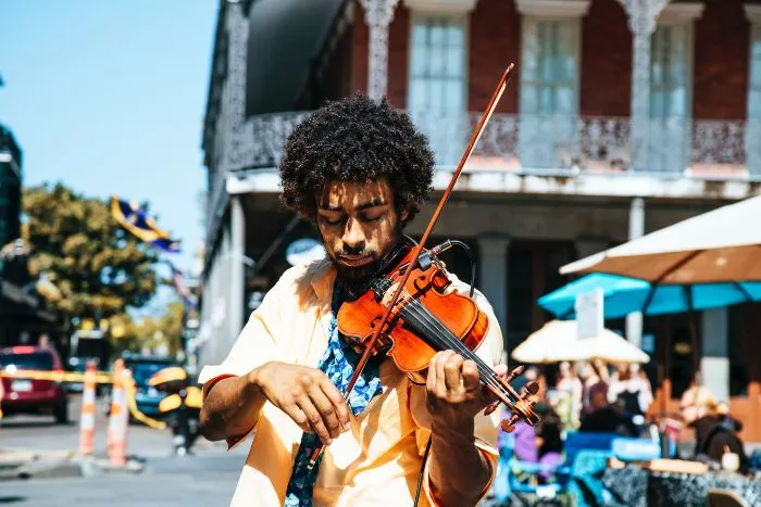 A man plays a violin in on the street in the historic French Quarter of New Orleans