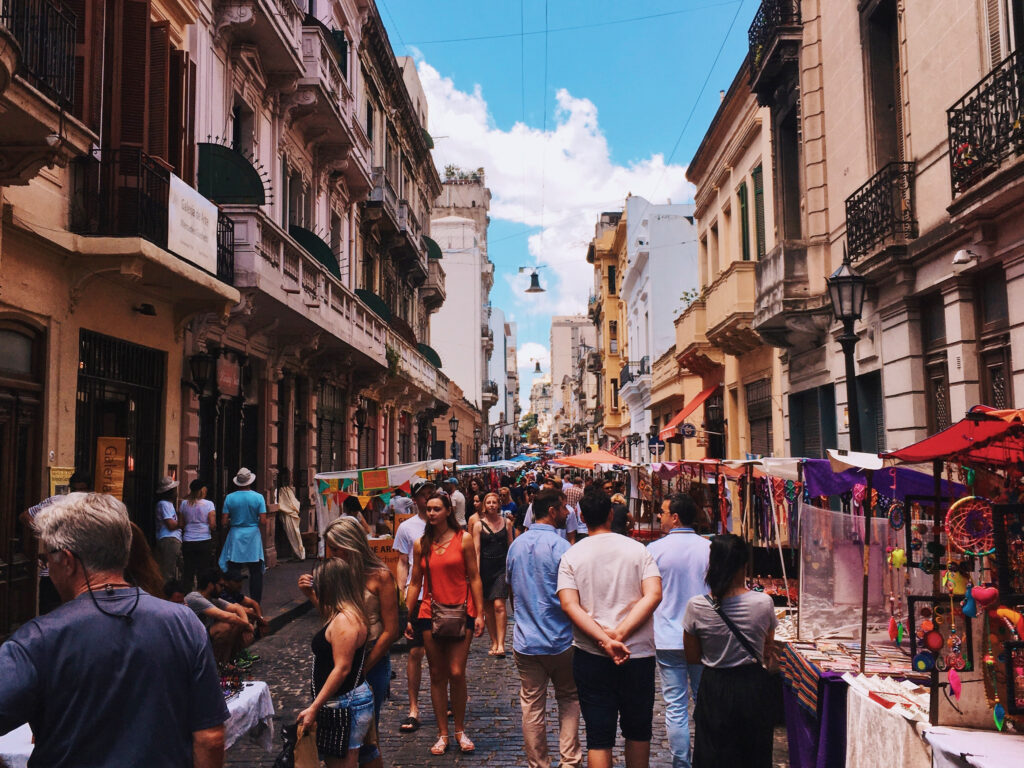 College students exploring a lively street market on a group trip, perfect for those interested in local culture and unique travel experiences.