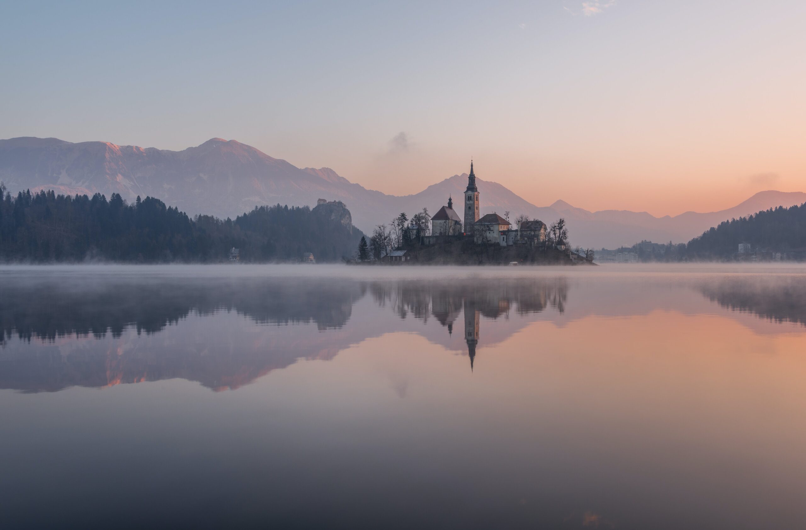 Misty morning at Lake Bled, Slovenia, a picturesque budget-friendly winter locale for college travelers.
