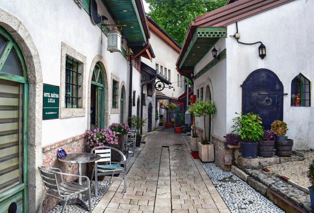 Image 3 Alt Text: "Quaint European-style alleyway with cobblestone paths, inviting outdoor seating, and flourishing potted plants, capturing the essence of a cultural escape perfect for students looking for a peaceful study spot abroad.