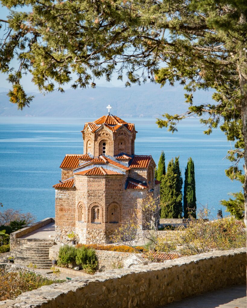 Historic stone church perched on a hillside with panoramic sea views, ideal for student travelers exploring cultural sites.