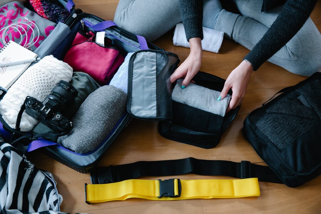 Image of college girl packing her clothes in packing cubes from the top down.