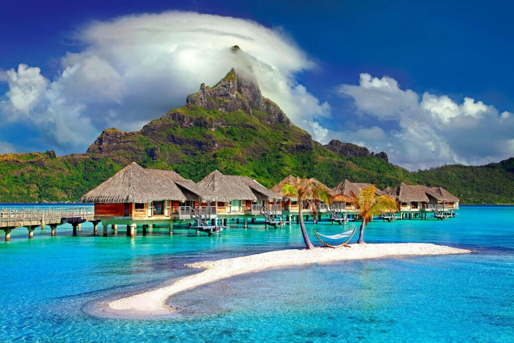 Overwater bungalows with a view of a majestic mountain in Bora Bora, a dream Mother's Day destination accessible through student travel deals.