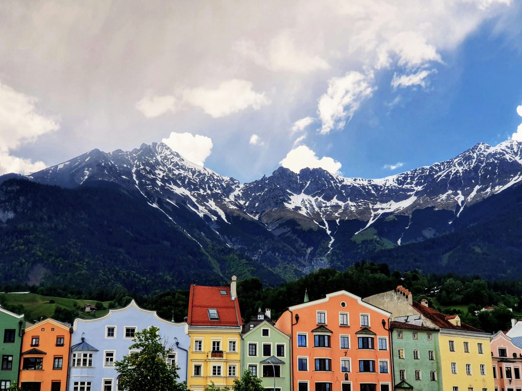 Colorful alpine houses in Innsbruck, Austria with snow-capped Nordkette mountains in the background — a top student travel destination in Europe for scenic getaways.