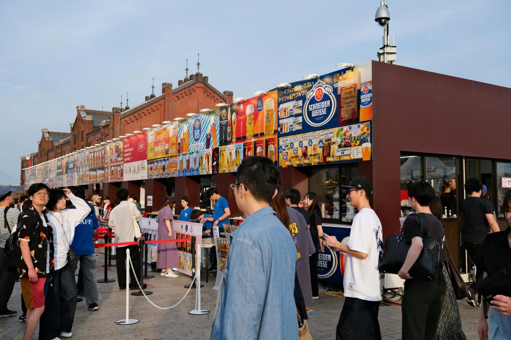 Beer stalls and queues at Yokohama Red Brick Warehouse Oktoberfest in Japan.