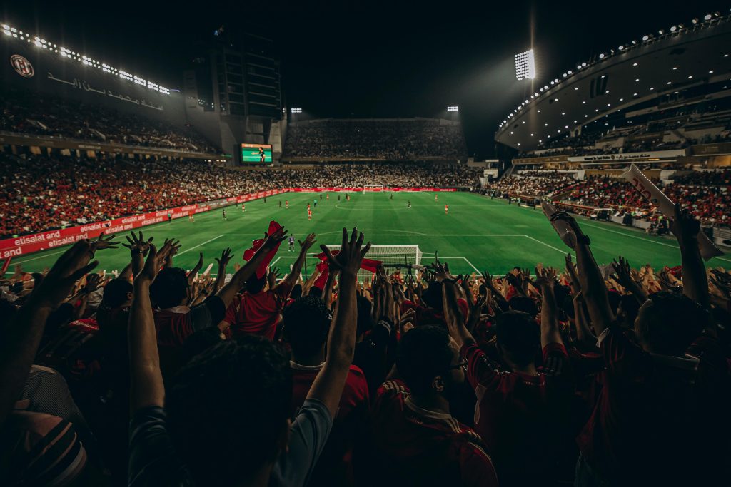 Fans celebrating during a packed FIFA World Cup soccer match in a stadium
