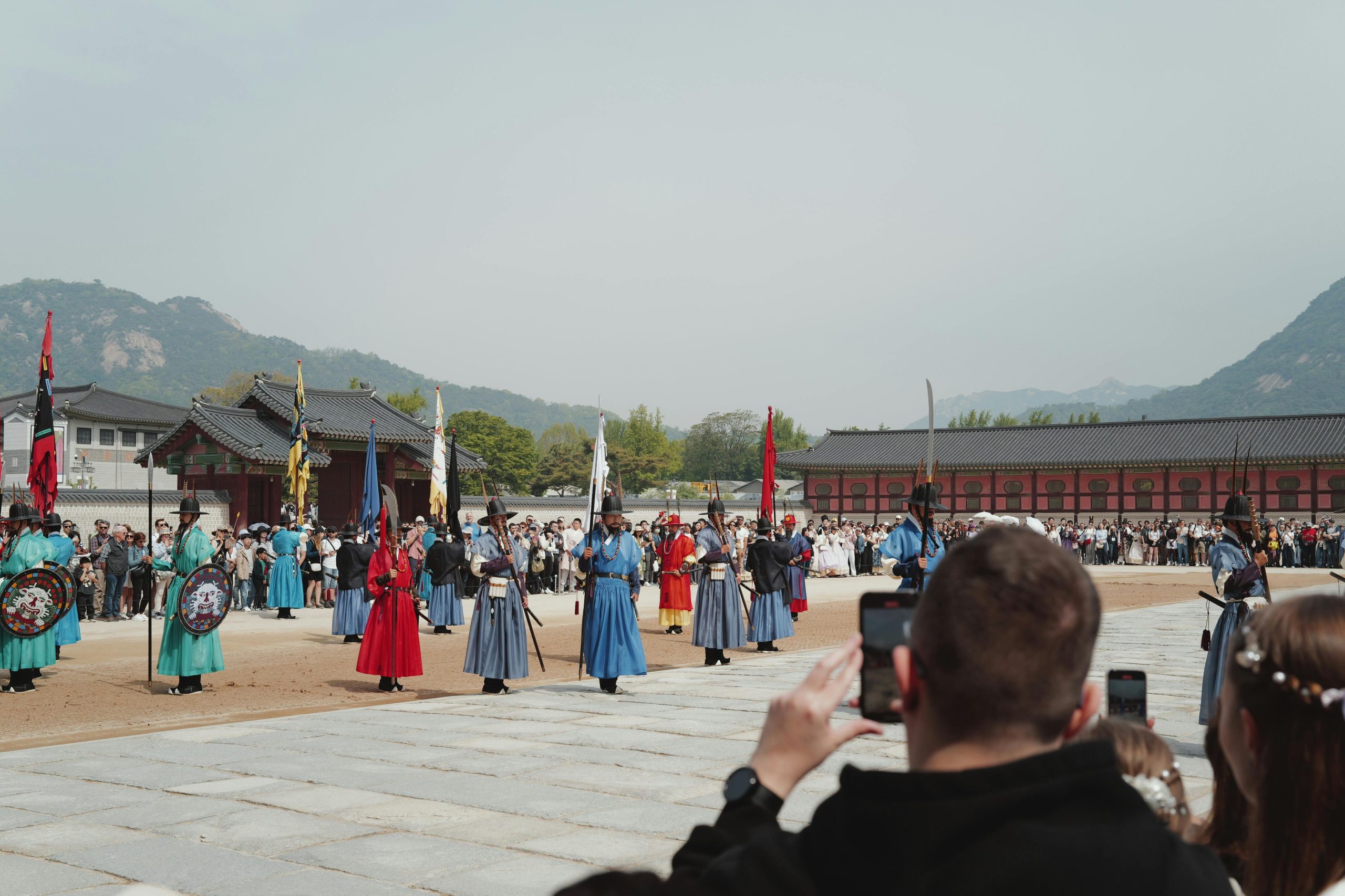 Travelers watch a traditional guard ceremony at Gyeongbokgung Palace in Seoul, South Korea.